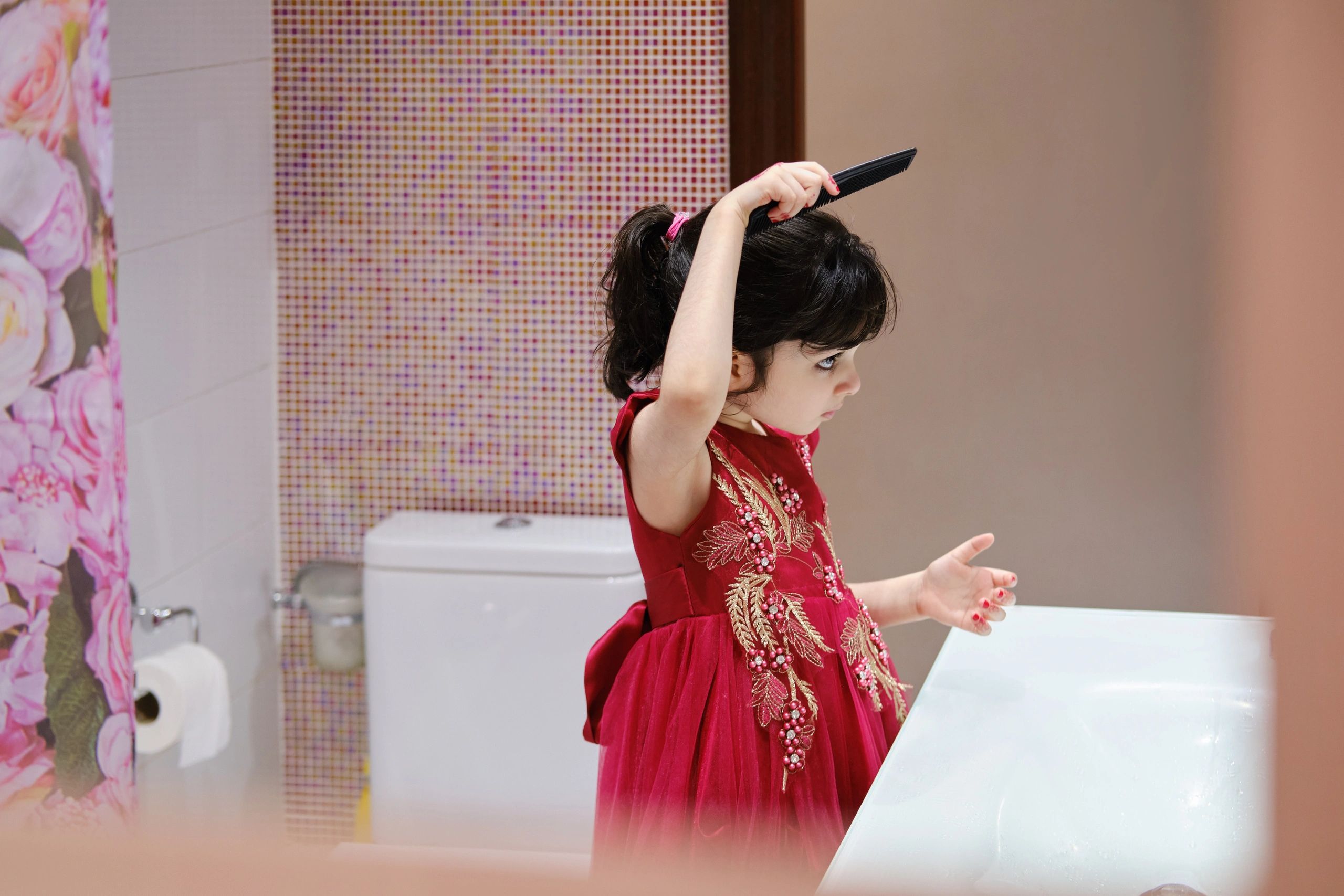 Little girl wearing traditional clothes and brushing hair