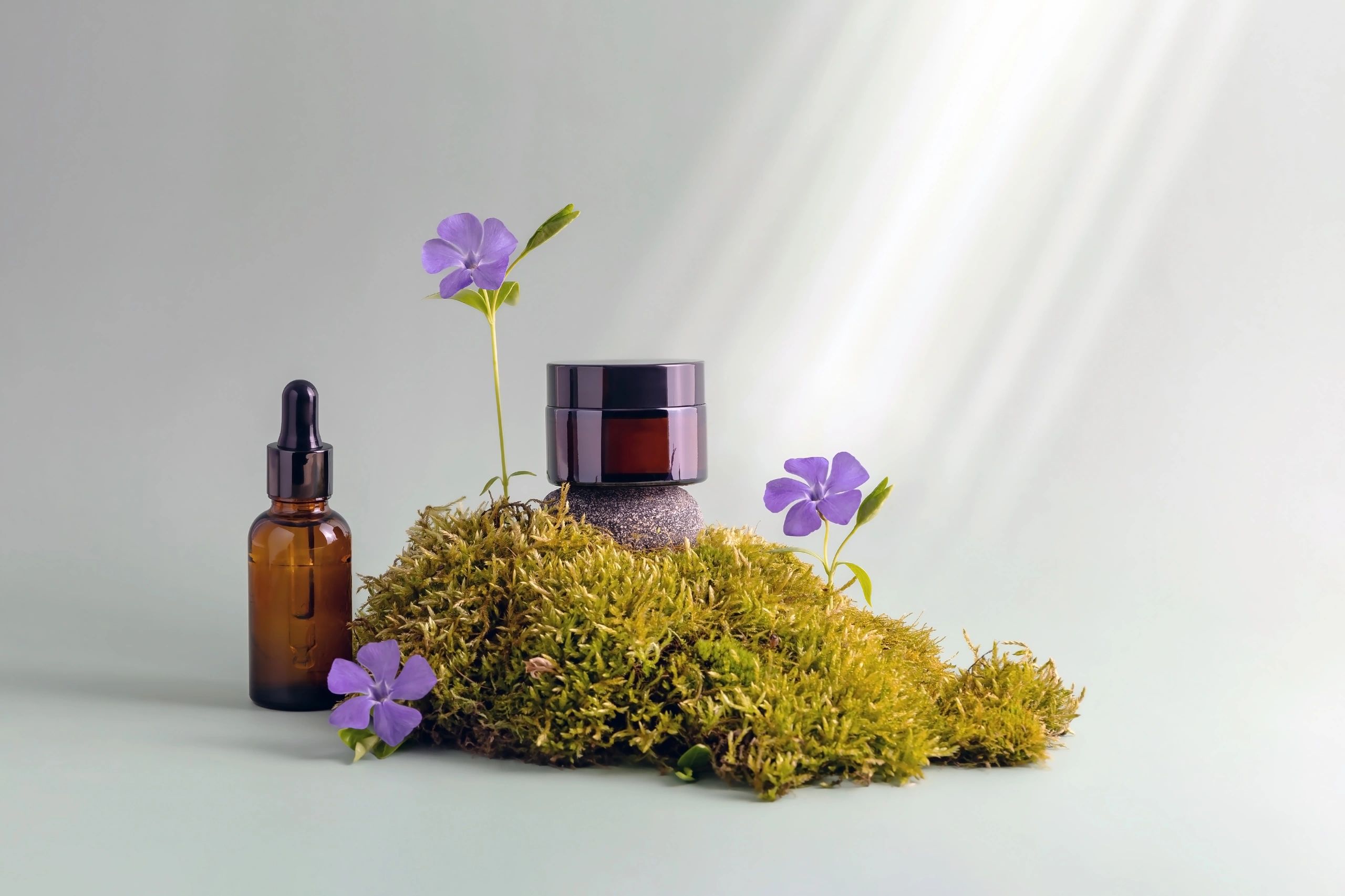 Beauty product containers styled with flowers and soft light