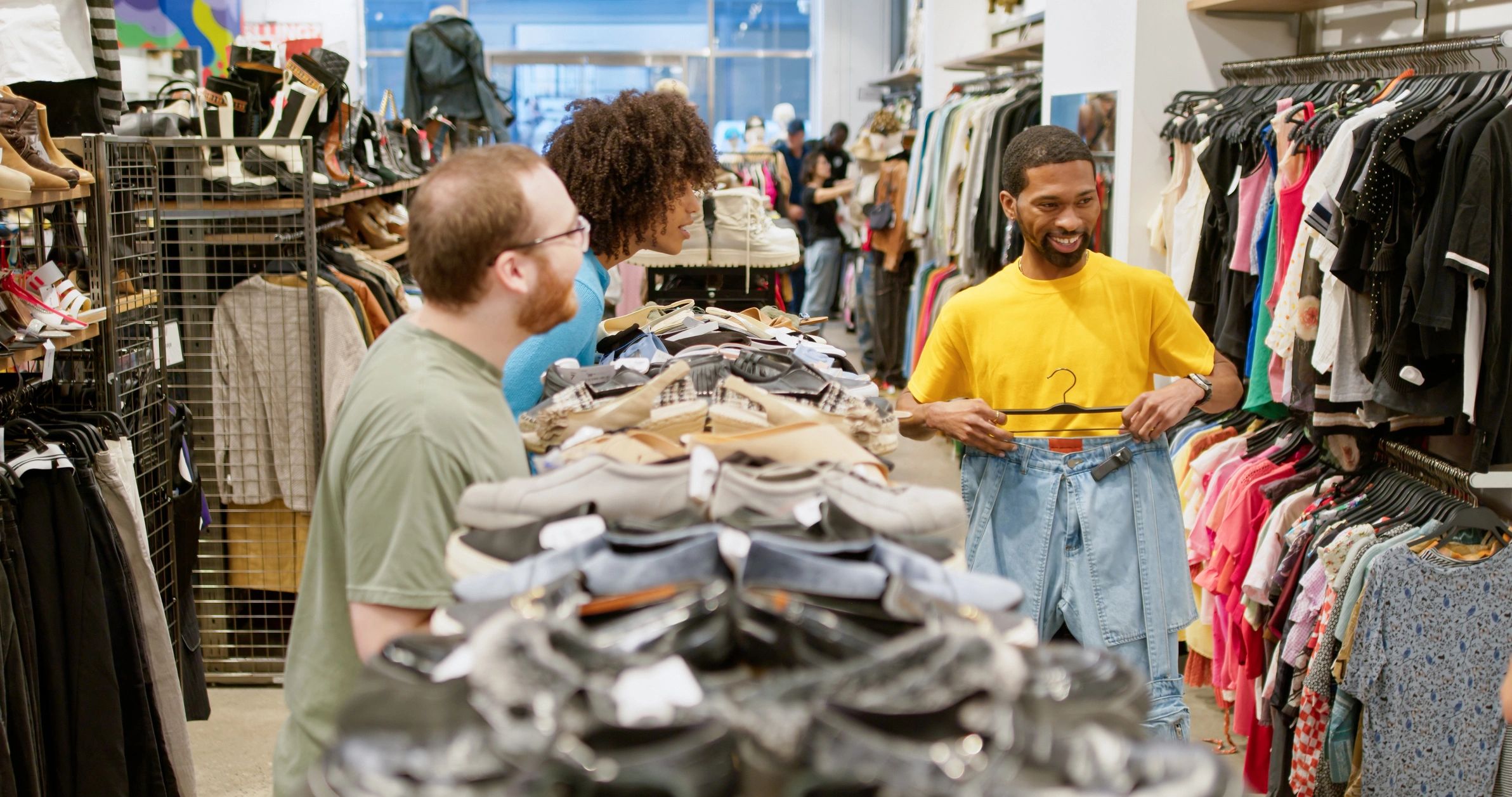 Diverse shoppers browsing clothing together in a stylish boutique