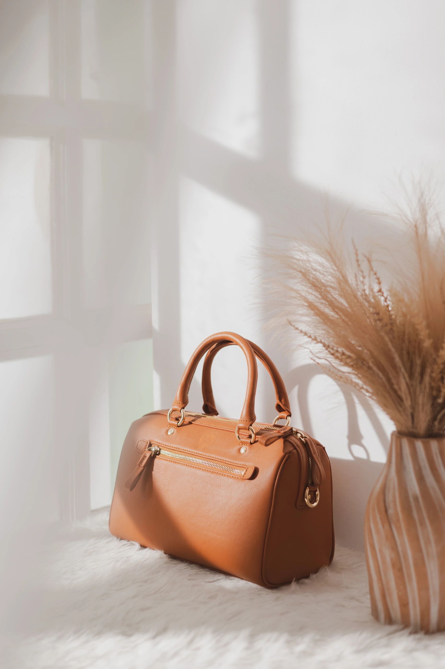 Tan leather handbag styled in soft natural light
