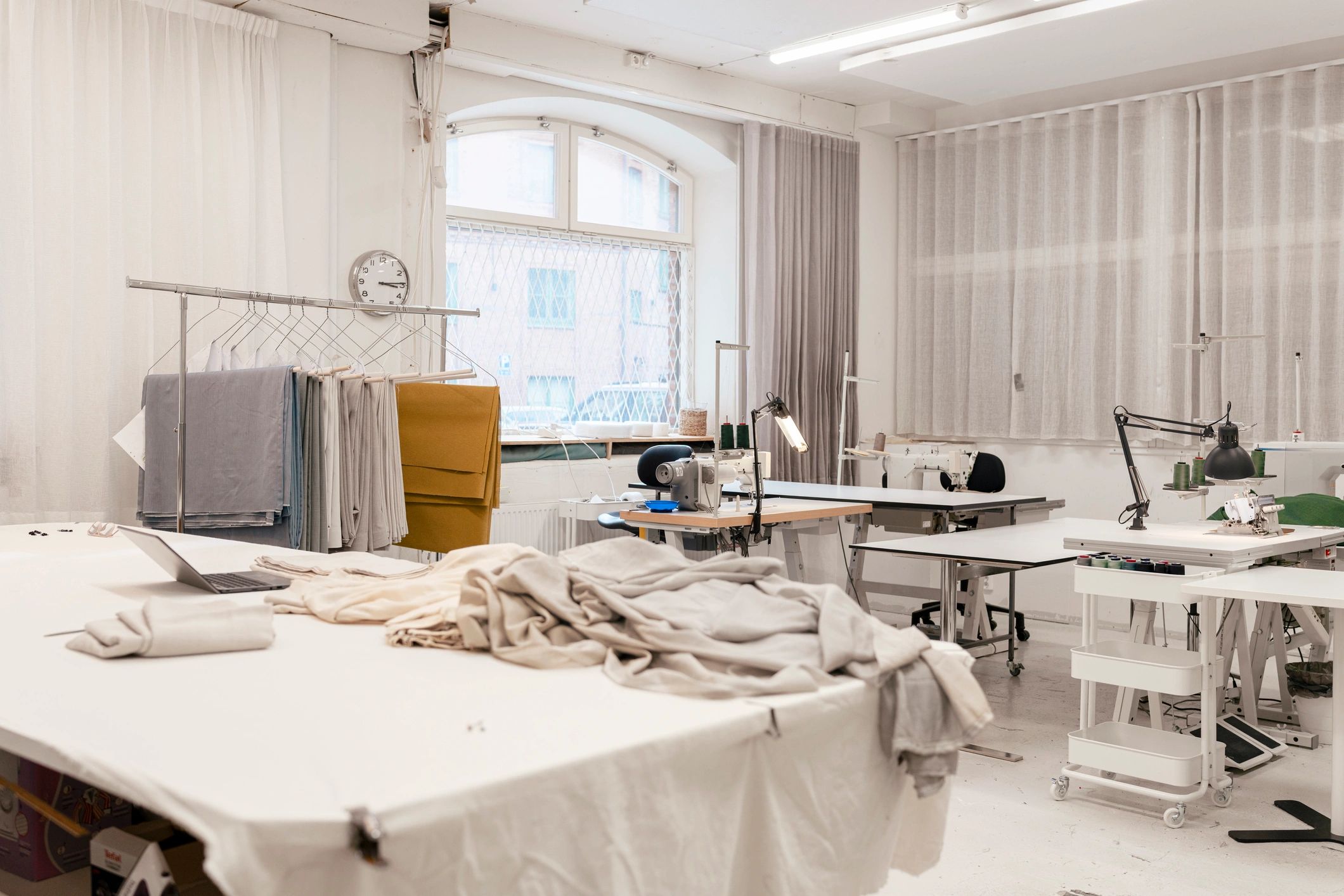 Bright fashion workshop studio with fabrics and garment production tools